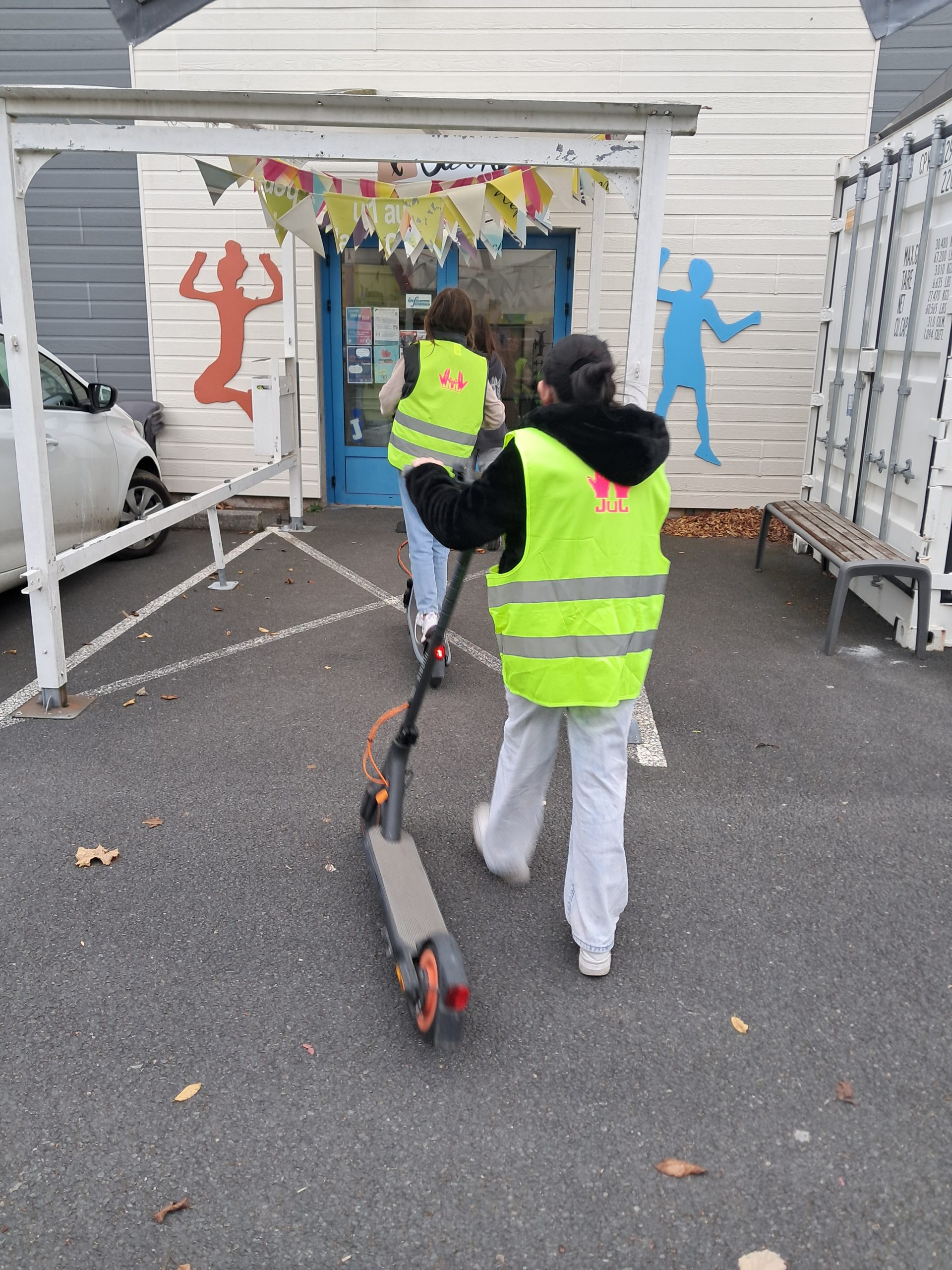 jeunes en trottinette avec gilets floqués